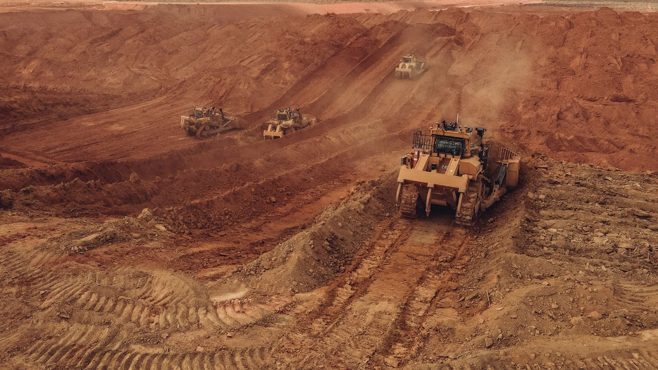 Crafting Captivating Headlines: Your awesome post title goes here Aerial shot of heavy machinery at work in a Brazilian open pit mine with dusty red earth, depicting industrial operation.